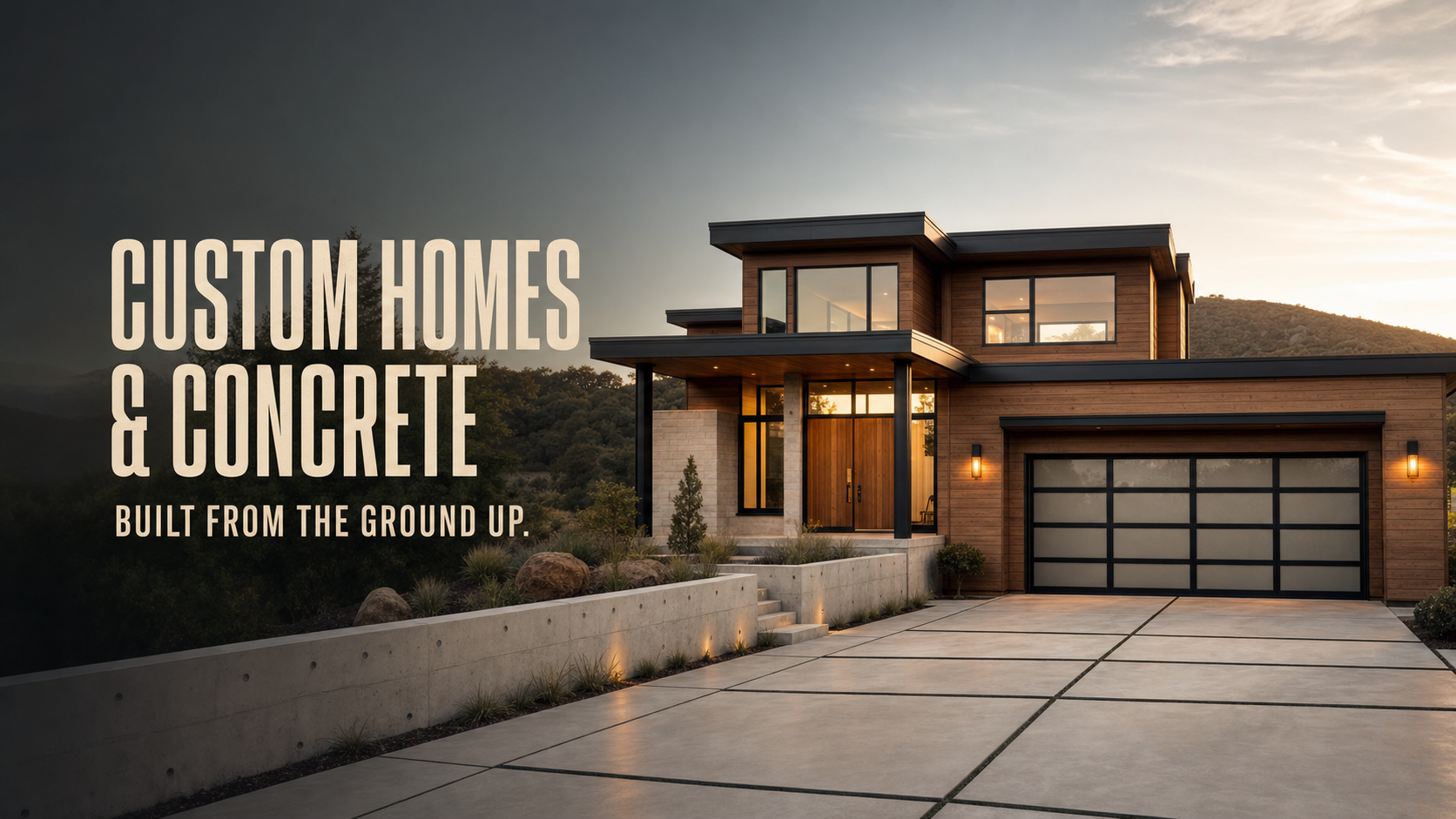 Contemporary cedar home with a finished concrete driveway and landscape walls at golden hour